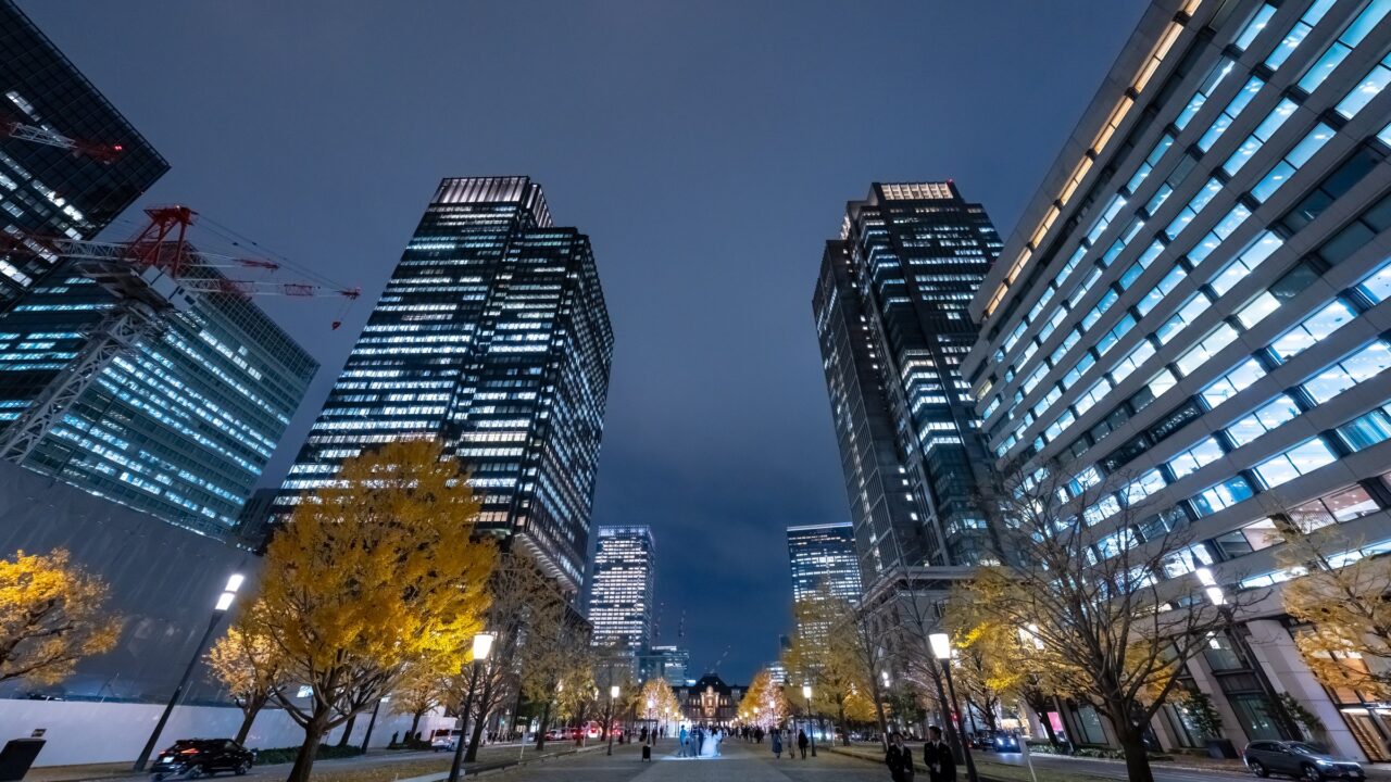 Office towers and a wide avenue in central Tokyo at dusk