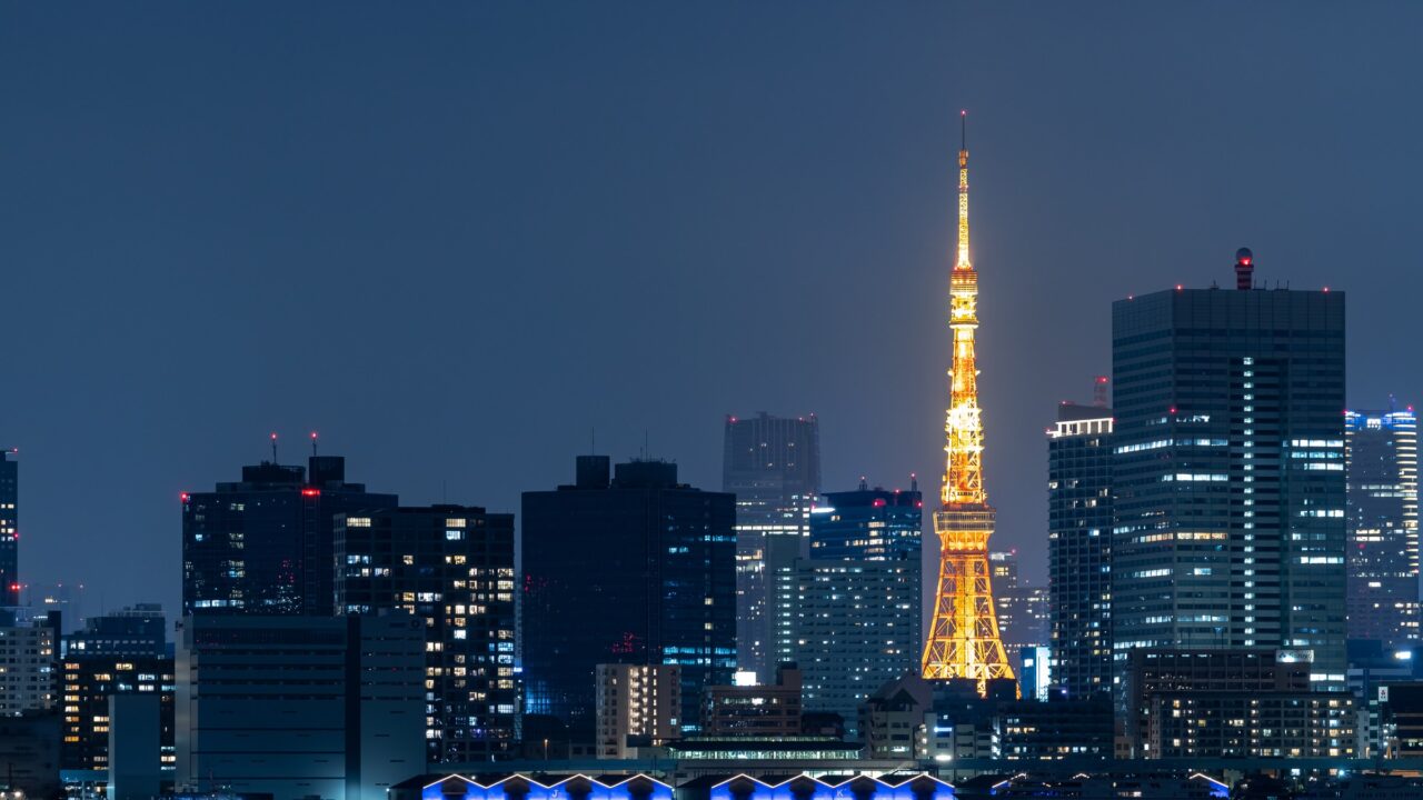 Tokyo Tower lit orange among office towers at night